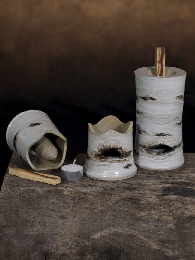 Ceramic palo santo wood burners showing the component parts (base with candle tea light, upper body with suspended tube for the palo santo stick and an assembled example.