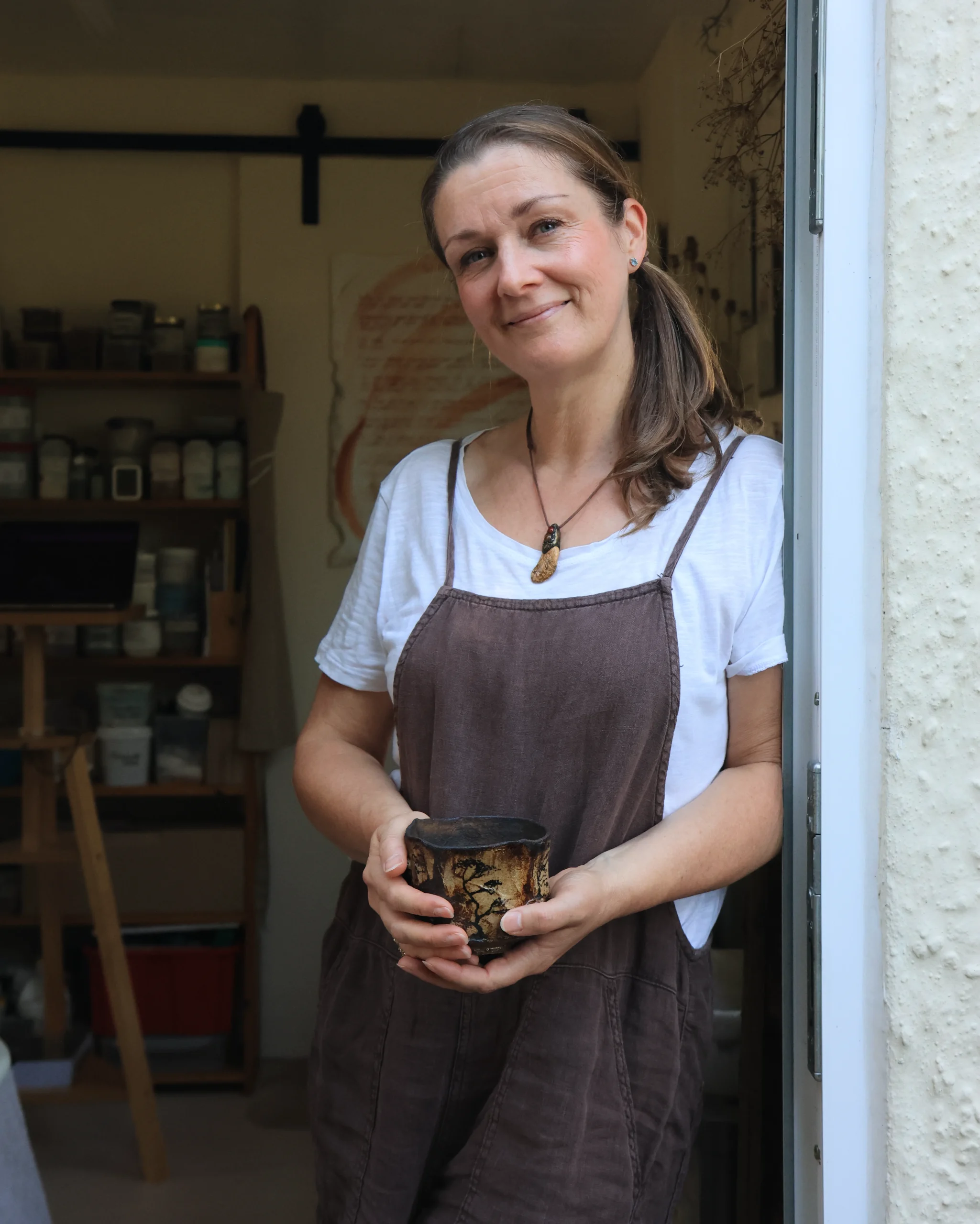 Sonya Wilkins stood at the doorway of her ceramics studio holding one of her Tree Chawan tea bowls